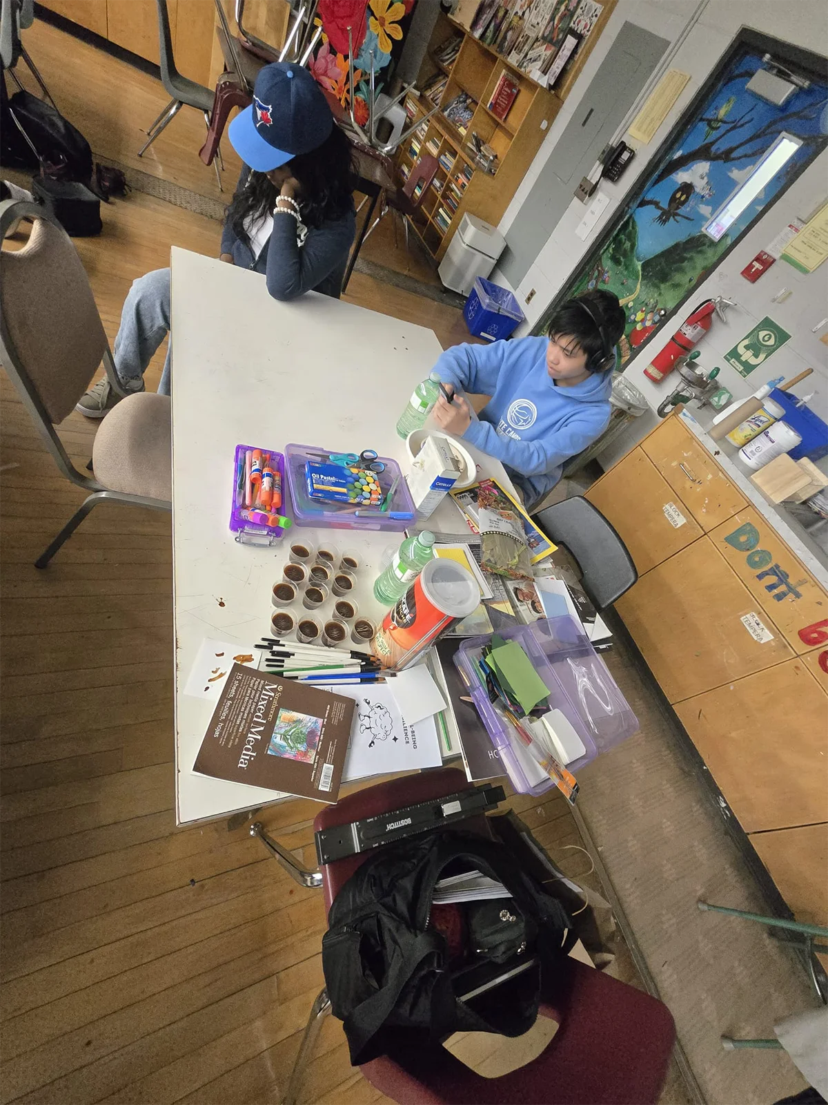 Youth exploring mixed media art materials and pastels during creative expression exercise