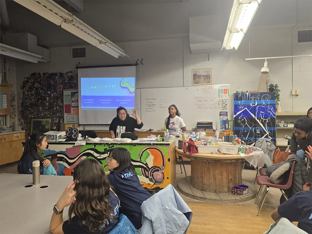 Workshop facilitator leading mindfulness and art discussion with projector slides