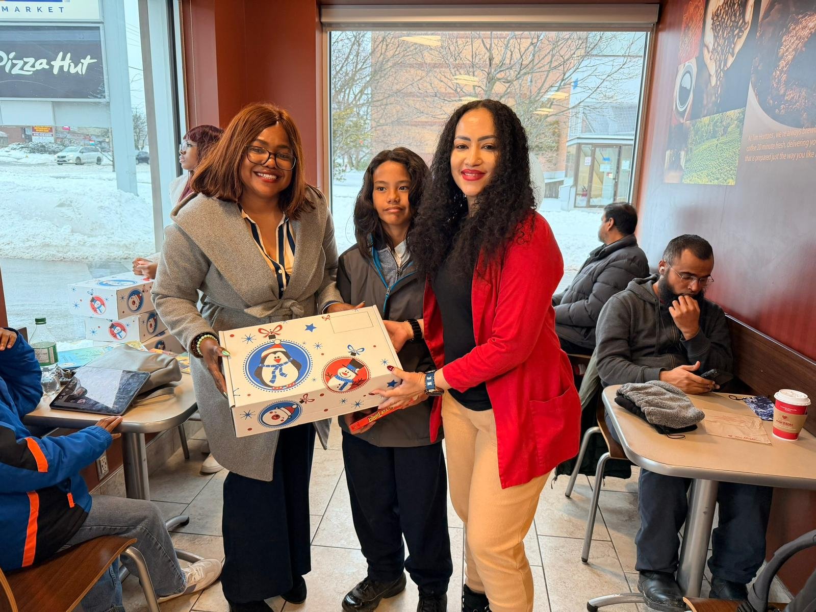Families gathered warmly indoors receiving holiday celebration packages