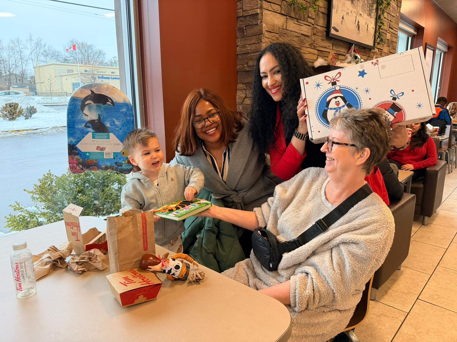Young child, mothers and seniors sharing joy with children books and gift boxes