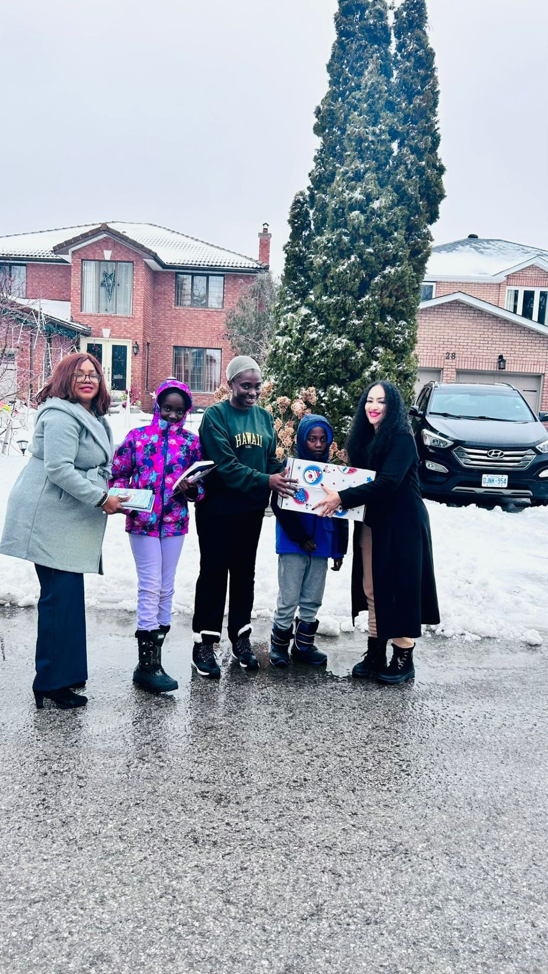 Young girl beaming with her new books and decorated holiday gift box
